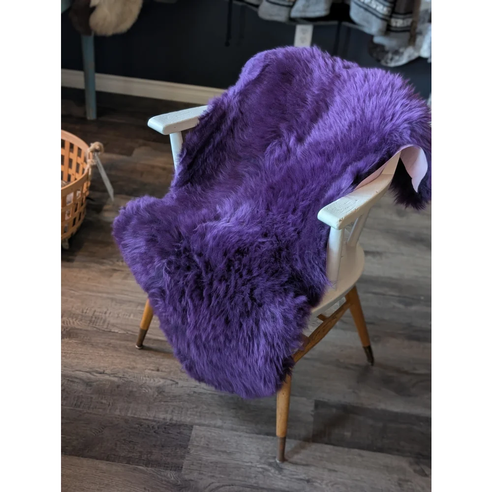 Gorgeous grape purple merino sheepskin throw with wooden legs and white frame