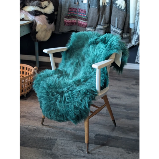 Teal faux fur armchair with white arms, wooden legs, gorgeous merino sheepskins