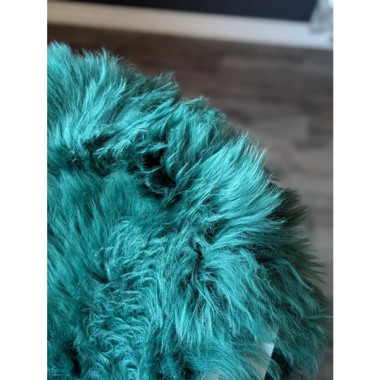 Teal faux fur ear warmer with pom-pom on gorgeous merino sheepskin
