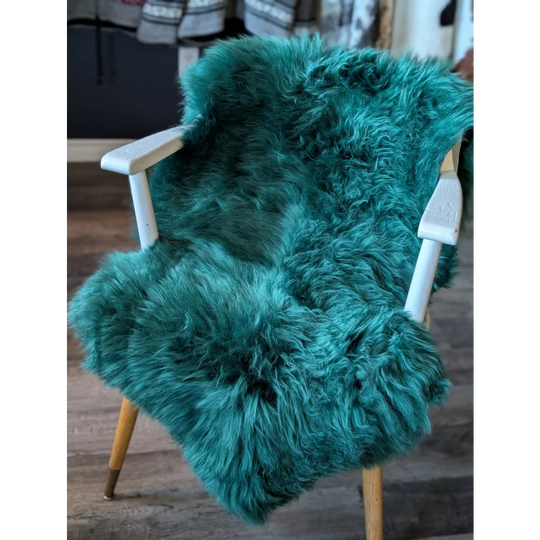 Teal faux fur armchair with white arms, wooden legs, gorgeous merino sheepskins