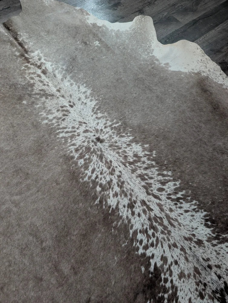 A beautiful extra large gray and white cowhide rug greymix925 with a distinctive spotted pattern perfect for large cowhide decor