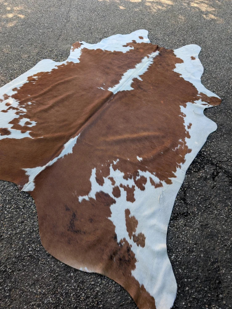 Brown and white large cowhide rug hello1 with natural irregular edges showcasing unique characteristics and beautiful rugs