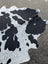 Hello 10 large cowhide rug in black and white with unique characteristics and rustic charm measuring 92 by 73.5 inches