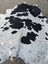 Large black and white cowhide rug hello10 with unique characteristics and rustic charm in a natural irregular pattern