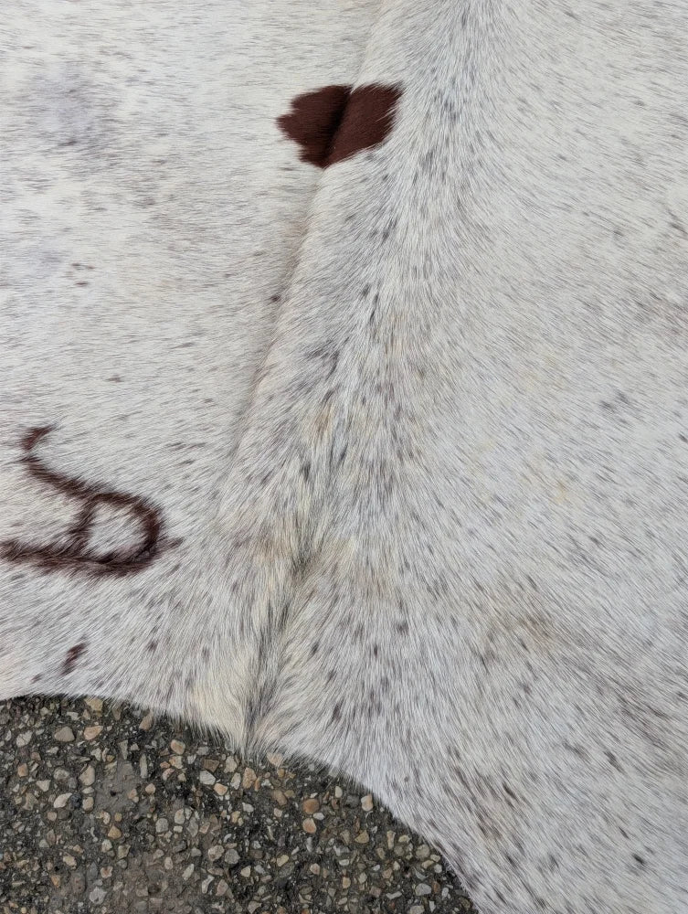 Hello12 large cowhide rug in white and gray speckled with a single dark brown spot perfect for beautiful rugs lovers