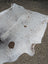 Extra large hello#14 cowhide rug with white and natural brown spots featuring unique characteristics and textured surface