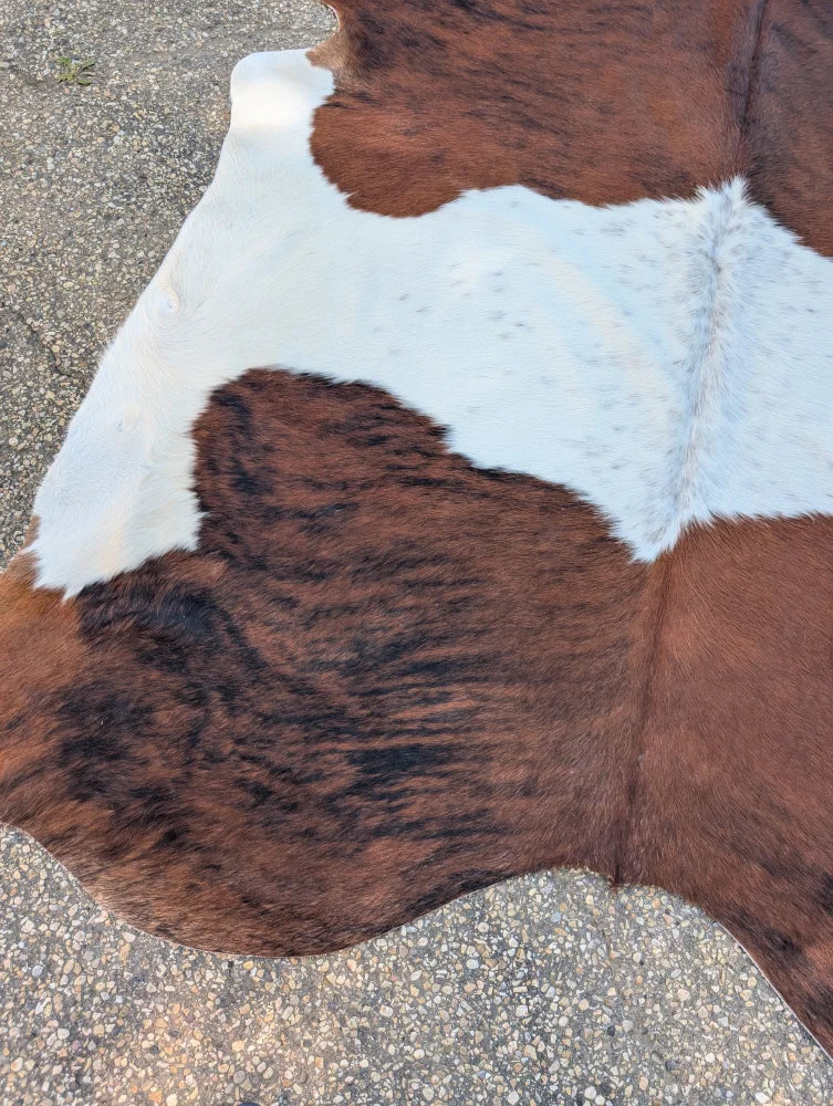 Large brown and white cowhide rug hello2 with natural fur texture and unique characteristics for rustic charm
