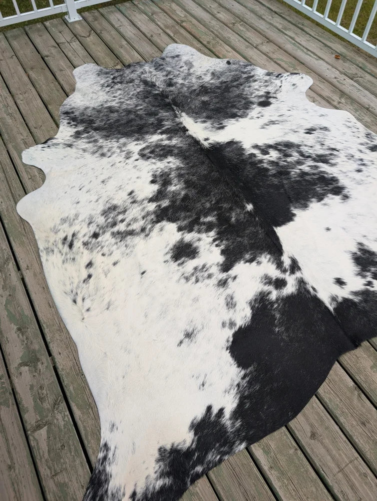 Hello6 large black and white cowhide rug with natural irregular edges showcasing unique characteristics in beautiful rugs
