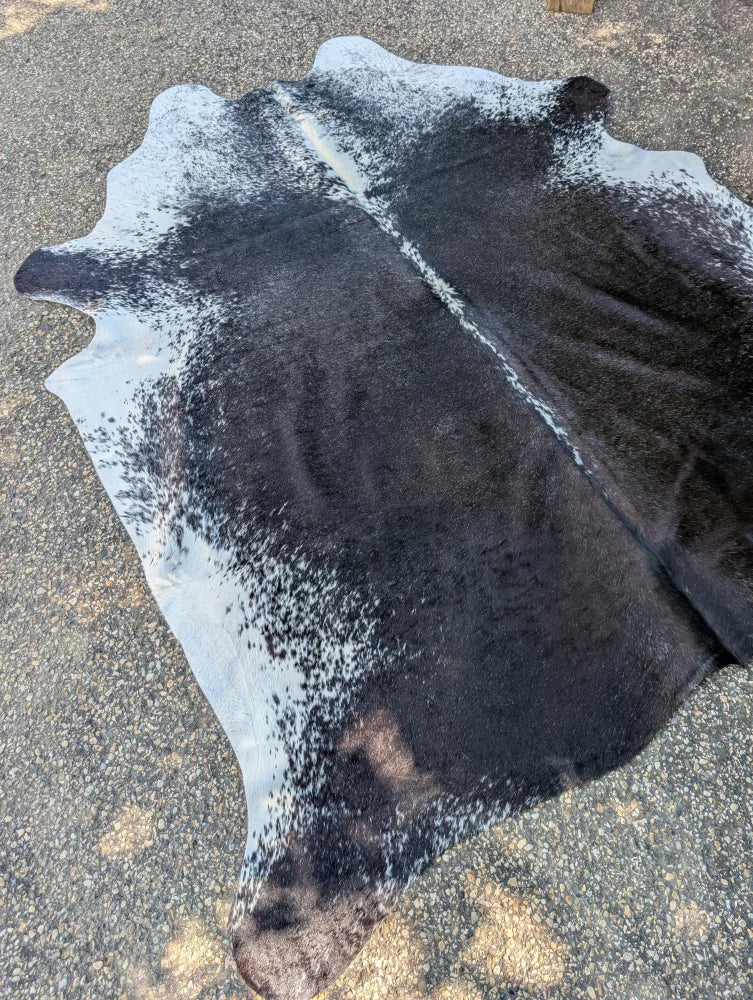Large black and white cowhide rug with rustic charm and unique characteristics featuring natural irregular edges