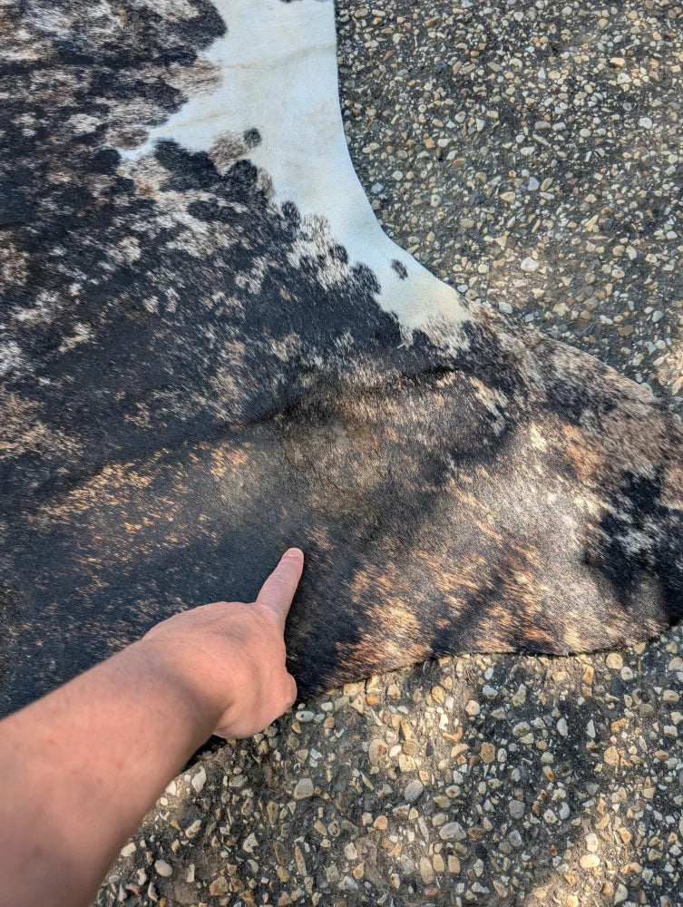 A large black and white cowhide rug with natural textured surface showcasing unique characteristics and rustic charm