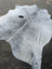 Large gray and white cowhide rug with unique characteristics and rustic charm featuring a natural irregular edge