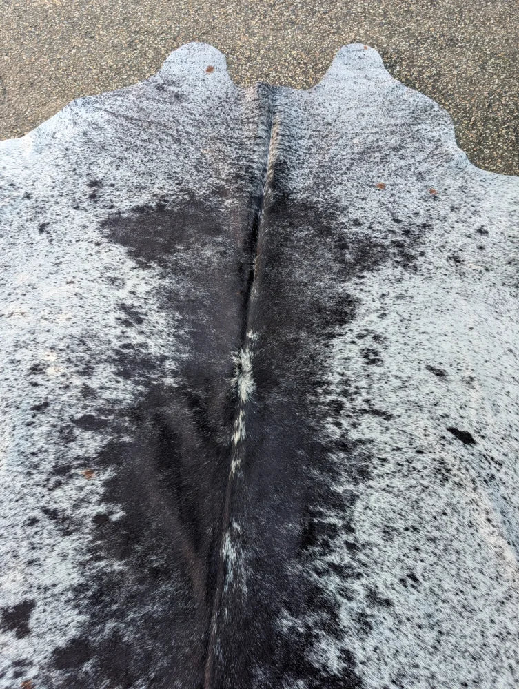 Large black and white speckled cowhide rug with natural fur texture showcasing unique characteristics and rustic charm