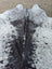 Large black and white speckled cowhide rug with natural fur texture showcasing unique characteristics and rustic charm