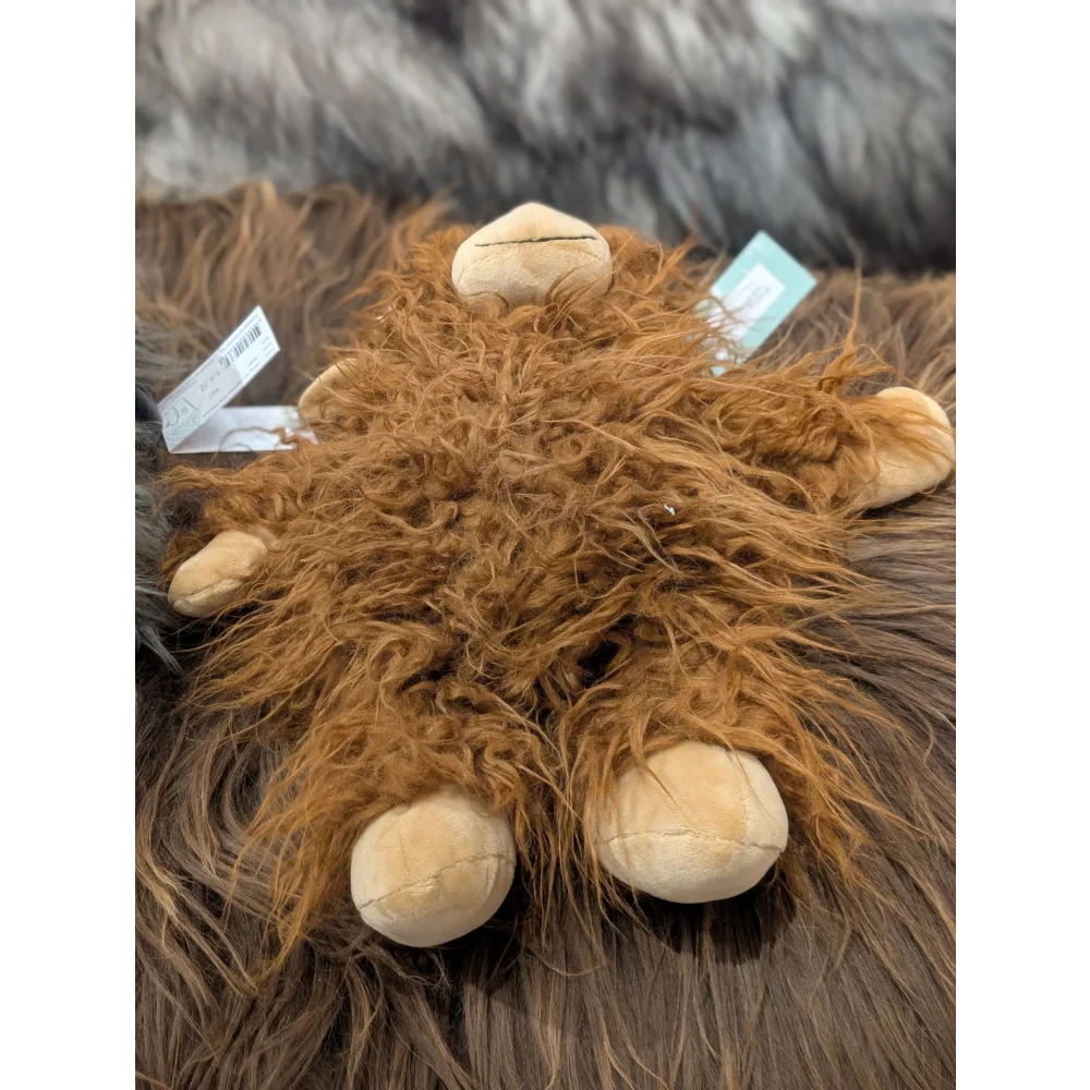 Henry the Cow plush toy with tan feet and green tags