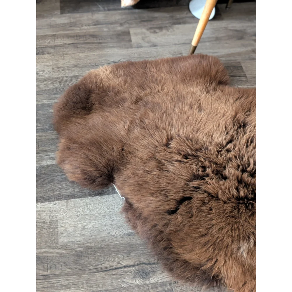 A plush extra large british sheepskin rug in medium brown with soft fluffy texture and natural irregular edges