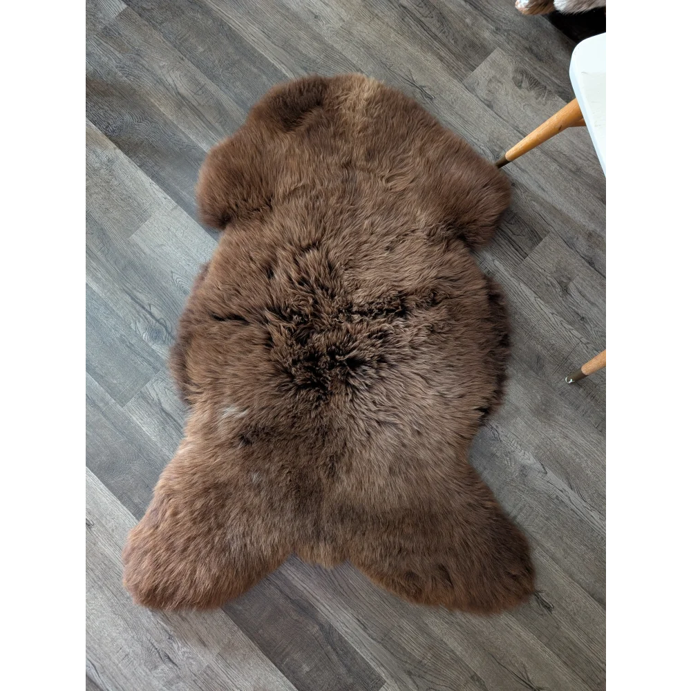 A plush extra large british brown sheepskin rug with soft fluffy texture and natural fur pattern 53 by 31 inches