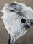 Large black and white spotted cowhide rug with unique characteristics and natural irregular edge perfect as a cowhide rug