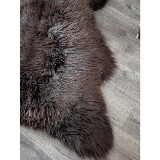 A plush dark brown angus oliver british sheepskin rug with dense fur on gray wood floor perfect sheepskin rugs canada