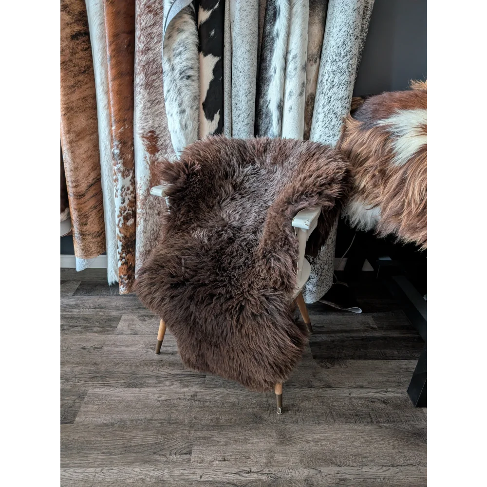 Brown fluffy angus oliver extra large british sheepskin rug draped over white chair with wooden legs canada sheepskin rugs