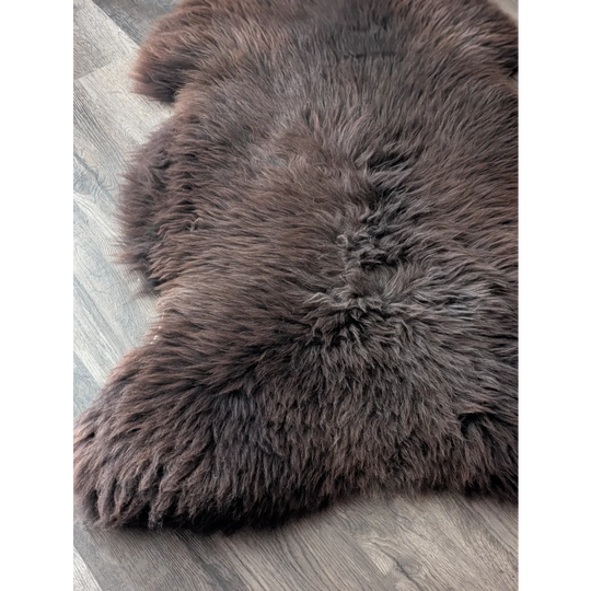 A plush extra large british sheepskin rug in dark brown with soft dense fur texture measuring 52 x 33 inches