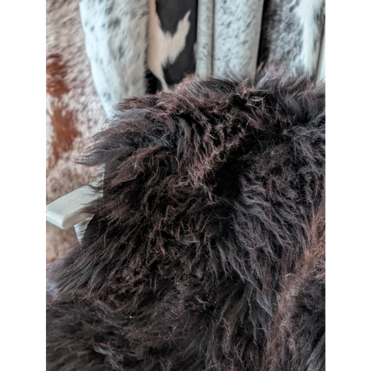 A plush dark brown angus oliver sheepskin throw with thick shaggy texture perfect for cozy canada homes