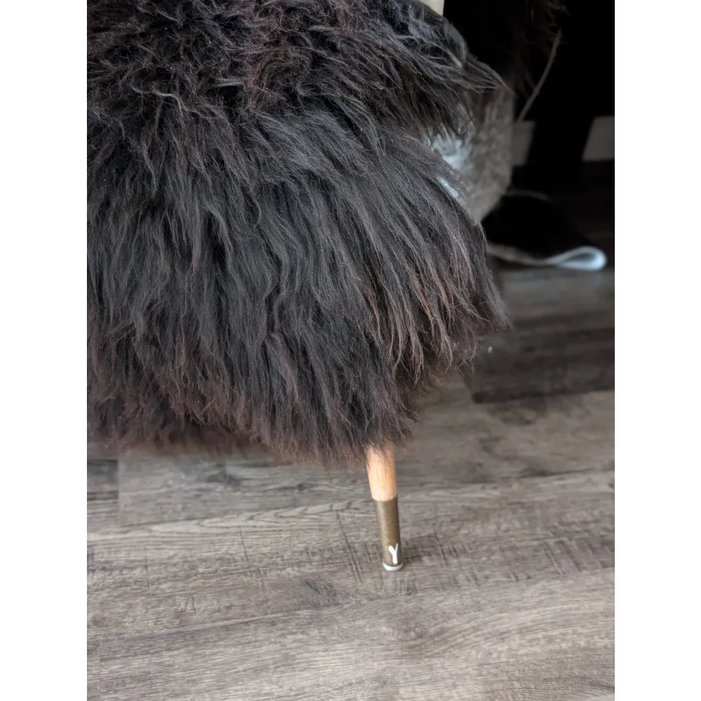 A plush dark brown faux fur chair with wooden legs and metal caps featured with angus oliver sheepskin rugs canada