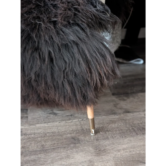 A plush dark brown faux fur chair with wooden legs and metal caps featured with angus oliver sheepskin rugs canada