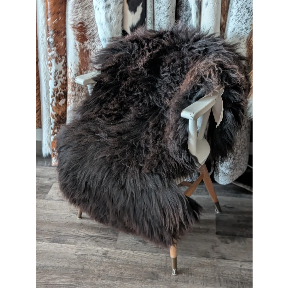 Thick dark brown extra large british sheepskin rug with long curly fur draped over white wooden chair angus oliver canada