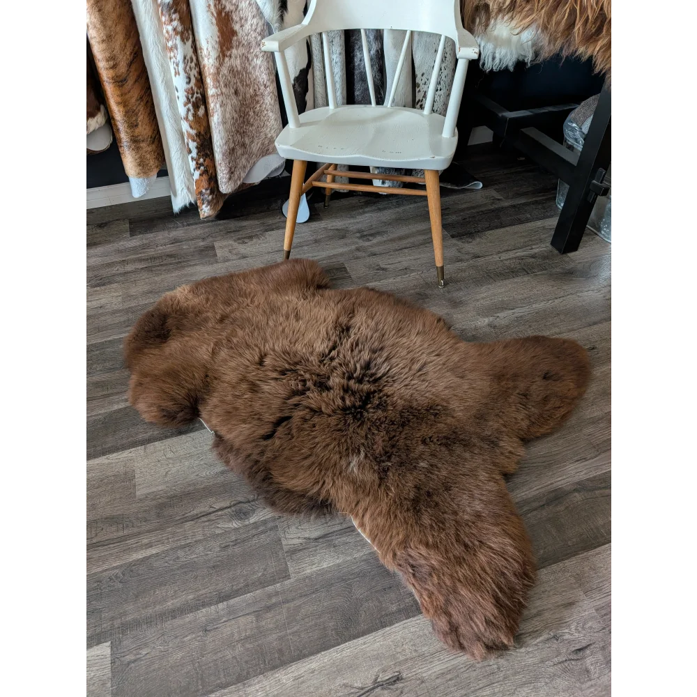 A gorgeous extra large brown british sheepskin rug by angus oliver with natural fluffy texture on wooden floor canada