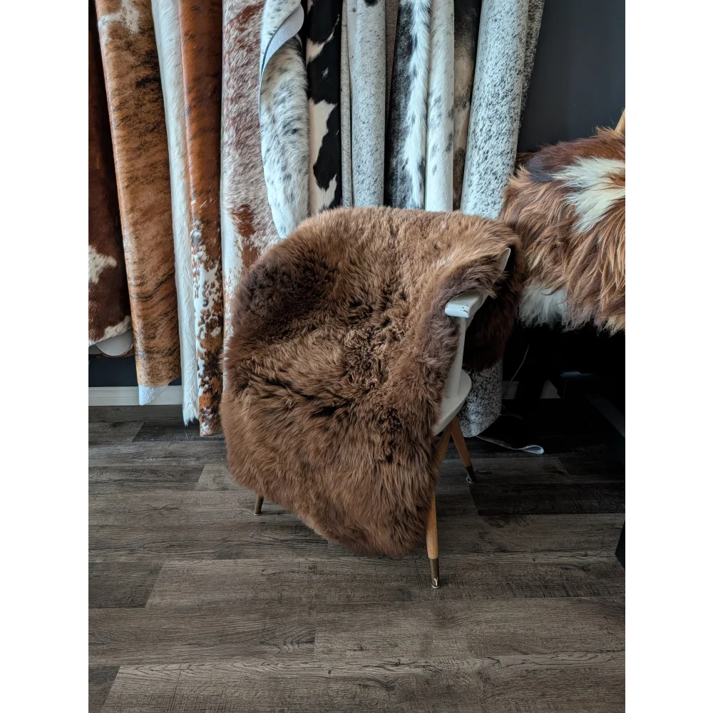 A plush brown british sheepskin rug 53 x 30 draped over a chair from angus oliver canada sheepskin rugs