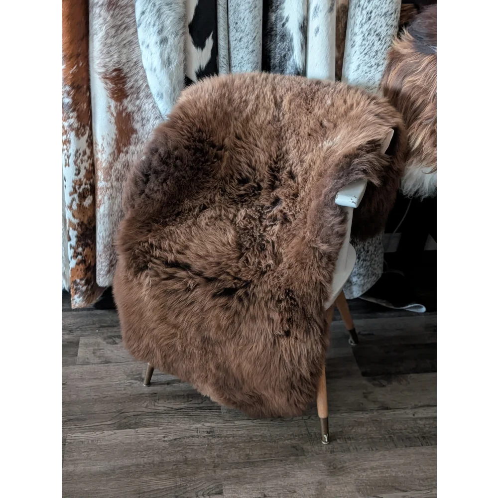 A gorgeous extra large british sheepskin chair cover in rich brown with fluffy texture from angus oliver canada