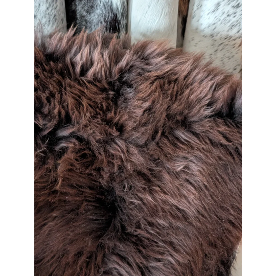 A plush deep brown extra large british sheepskin rug with thick shaggy texture 54 by 28 inches