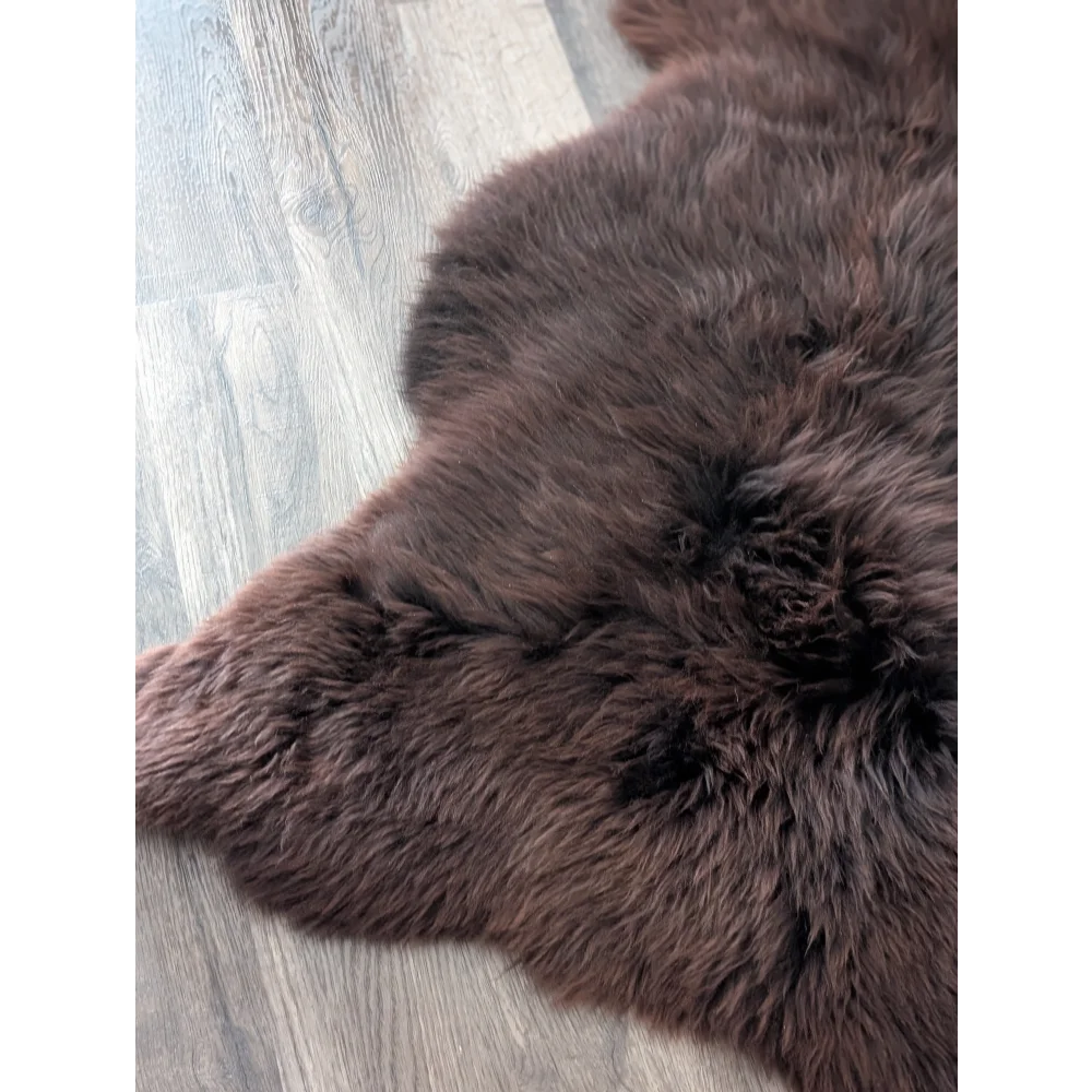 A gorgeous extra large dark brown british sheepskin rug by angus oliver canada on light gray wood floor perfect for cozy spaces