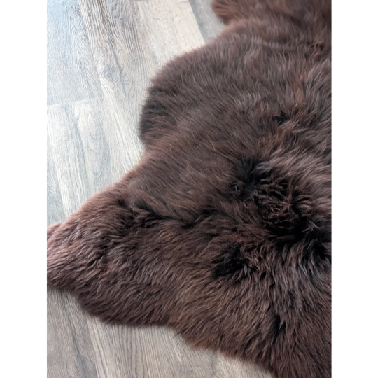 A gorgeous extra large dark brown british sheepskin rug by angus oliver canada on light gray wood floor perfect for cozy spaces