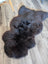 A plush dark brown british isles sheepskin rug with natural shape and soft dense fur measuring 53 by 27 inches