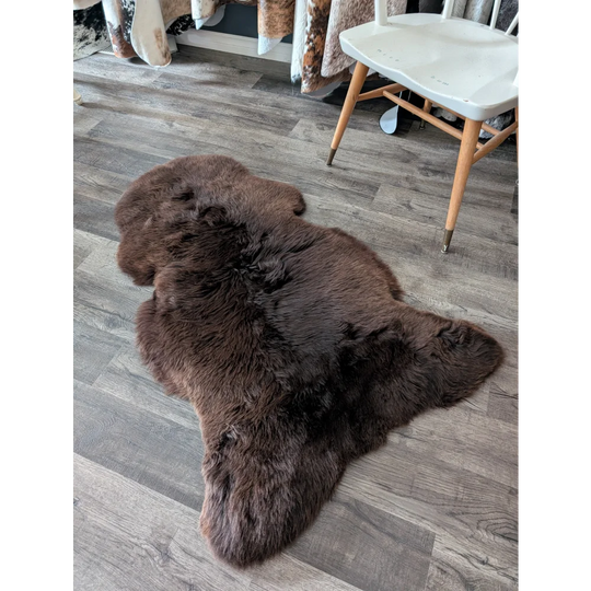 A gorgeous extra large dark brown british sheepskin rug by angus oliver with natural fluffy texture and irregular edges