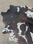 Hum12 92 x 80 extra large cowhide rug with natural brown and white spots showcasing unique characteristics in beautiful rugs
