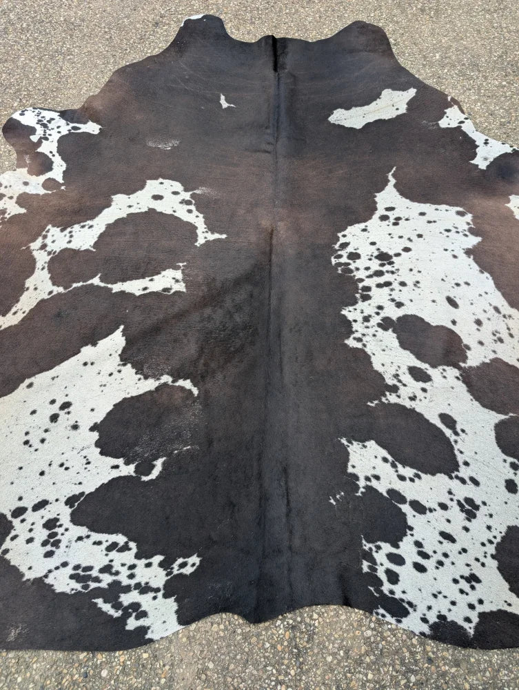 Extra large hum12 brown and white cowhide rug with natural black spots and unique characteristics for beautiful rugs