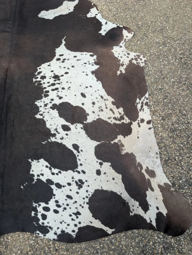 Brown and white large cowhide rug with natural black spots showcasing unique characteristics for beautiful rugs