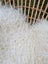 A plush white curly long wool icelandic sheepskin rug with soft fluffy texture perfect for cozy spaces