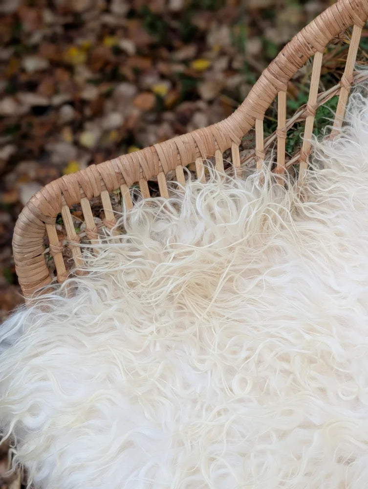 White fluffy wool icelandic sheepskin rug on woven wicker chair in ice2 49 by 30 curly long wool icelandic style