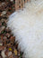A plush off-white curly fur throw blanket made of long wool icelandic sheepskin with soft voluminous texture