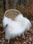 A cozy white long wool icelandic sheepskin rug draped over a woven wicker chair with metal legs