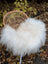 White fluffy long wool icelandic sheepskin throw draped over wicker chair for cozy decor