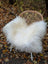 White fluffy wool icelandic sheepskin throw draped over wicker chair in 52 by 32 inch long wool icelandic style