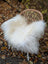 White fluffy long wool icelandic sheepskin throw draped over woven wicker chair for cozy decor