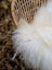 A plush off-white long wool icelandic sheepskin throw draped over a woven rattan chair for cozy style