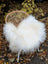 White fluffy long wool icelandic sheepskin throw draped over a wicker chair for cozy decor