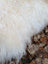A plush creamy white long wool icelandic sheepskin blanket with curly fibers perfect for cozy home decor