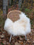 Cozy white long wool icelandic sheepskin draped over a wicker chair with slender metal legs for stylish comfort